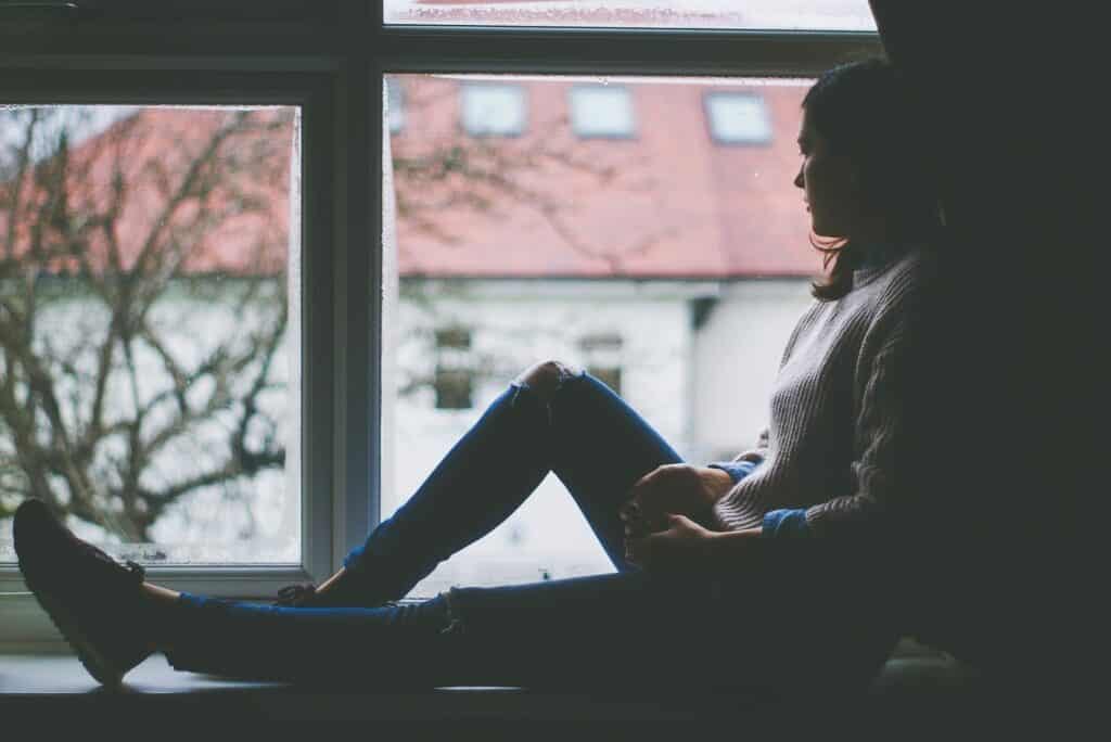 A woman sitting on a window sill.