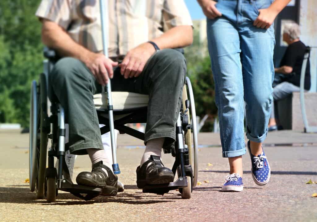 A man in a wheelchair next to a woman.
