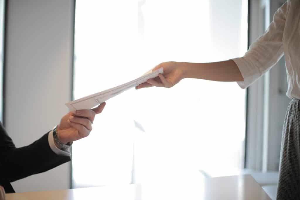 A man handing a woman legal paperwork.