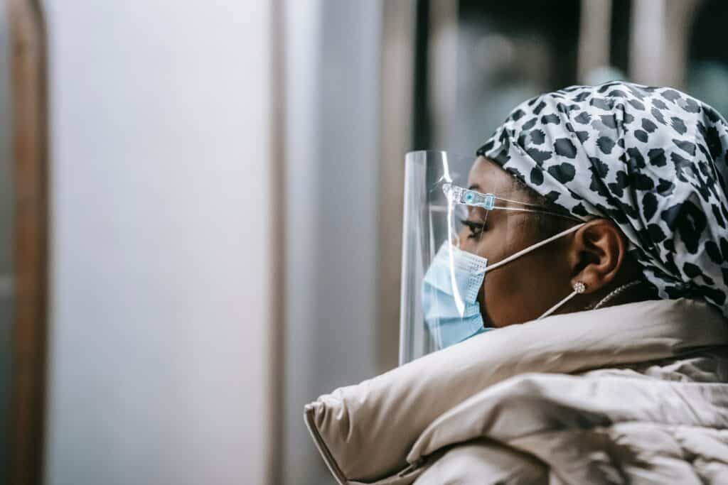 A woman wearing a surgical mask on a train.