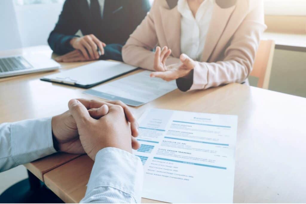 A group of people sitting at a table discussing employment law issues with a resume in front of them.