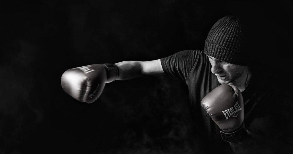 A man wearing a beanie and boxing gloves, seeking advice from an employment lawyer.
