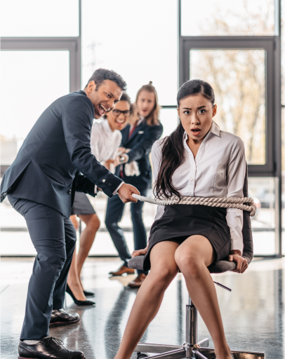 A man in business attire pulls a rope tied around a woman seated on an office chair, while two colleagues watch and react in the background, highlighting subtle workplace race discrimination dynamics.