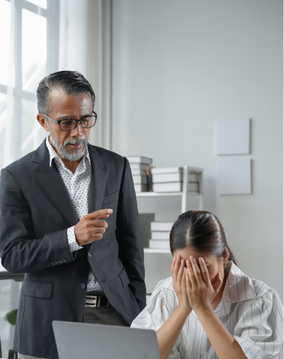 A man in a suit is pointing and speaking to a woman, who appears distressed with her face in her hands, possibly discussing her options for medical leave under the Family Medical Leave Act (FMLA).