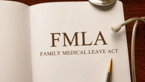 Open folder with "FMLA Family Medical Leave Act" printed on paper, shown with a stethoscope and a pen placed nearby—ideal for those seeking guidance from Philadelphia FMLA Lawyers.