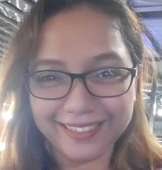 A person with long brown hair and glasses smiles at the camera in a well-lit indoor setting, representing Lacy Employment Law Firm.