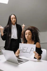 Three women seeking assistance from an employment lawyer with a sign that says help.